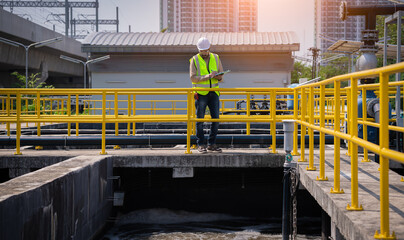 Worker under checking the waste water treatment pond industry large to control water support industry.	