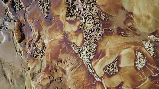 A vertical zoom shot was made rising above the desert-like yellow and brown land in Vietnam. Dry soil reminds of Mars exploration and interplanetary travel