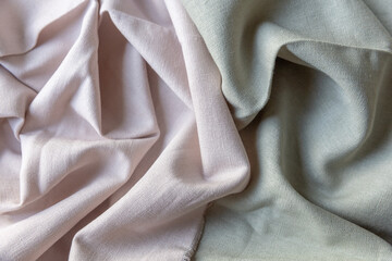 Textured folds of linen fabric in pastel pink and green colors. Textile background, top view,...