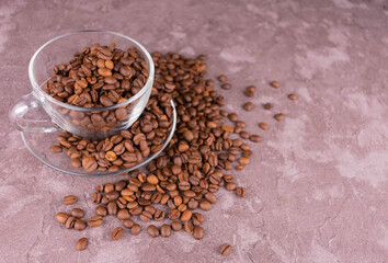 A cup full of coffee beans on a gray background.Copy space.