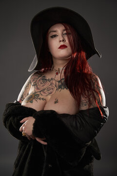 Tattooed plus size woman in fur and hat