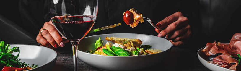 woman hand eating healthy salad from bowl sitting in cafe or restaurant