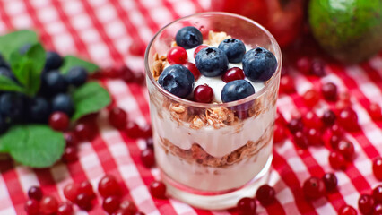 layers of yogurt and granola with cranberries and blueberries on top