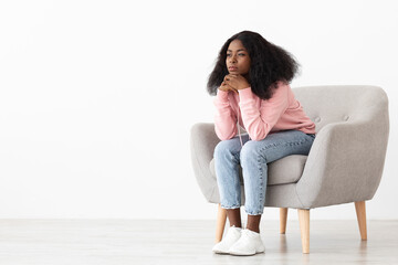 Upset african american woman sitting at arm chair, copy space