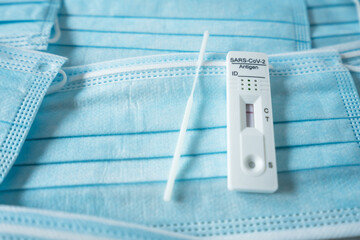 Negative home testing covid antigen card laying on face masks.