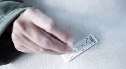 Person performs testing at home with sars cov 2 antigen test card kit.