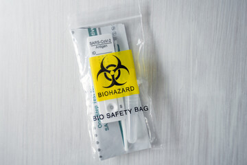 Antigen home testing sars cov 2 testing kit in bio safety bag with biohazard logo.