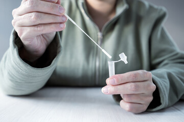 Person performs testing at home with sars cov 2 antigen test card kit.