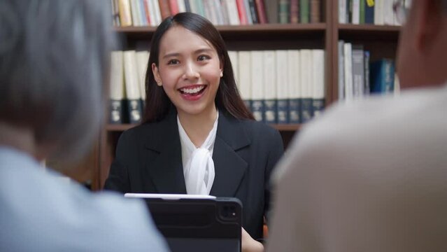 Happy young Asian financial planer professional advisor talking and presenting financial retirement plan to the mature retirement couple at home office.