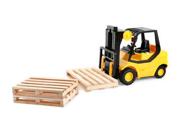Toy forklift truck with wooden pallets on white background
