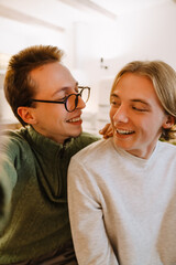 European gay couple laughing while taking selfie photo