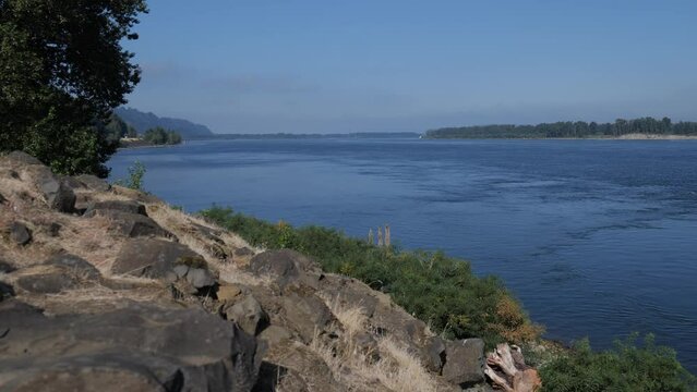 Columbia river at oregon looking west rocks tree left foreground clear sky. a corner of the american landscape