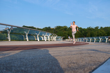 Full body portrait of a sportswoman, female athlete runner jogger enjoying morning jog on treadmill...