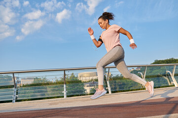 Female athlete, sportswoman, determined active woman jogging on a treadmill over the city bridge....