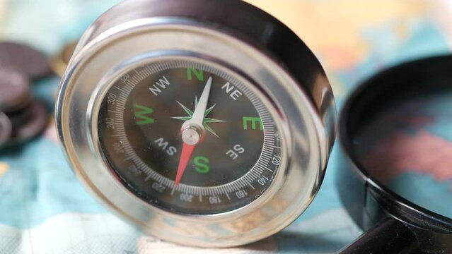 top view of holding a compus with travel map on table,