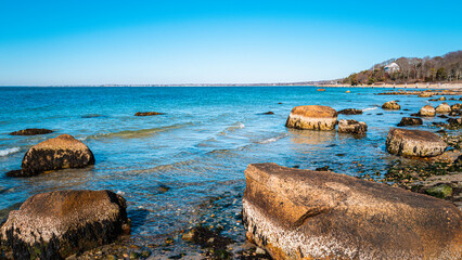 Costal landscape with many large boulders scattered around in the cove on Cape Cod.