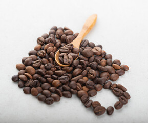 A cup of coffee beans with a wooden spoon inside. Blurred background