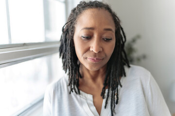 Portrait of an african woman close to a window look worry