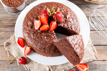 Clasic chocolate sponge cake Pan di Spagna with strawberry. Homemade cake. Top view