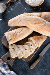 Baguette slices on a gray stone table. French bread