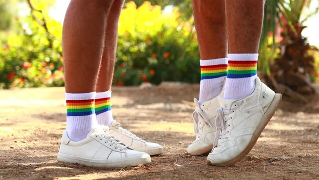close up of shoes with rainbow white socks of two young men while kiss outdoors