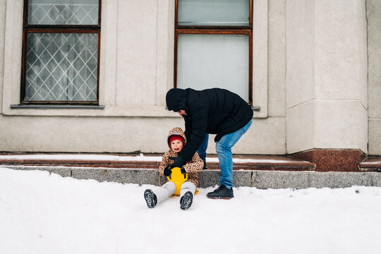 Father Near Kid On Saucer Sled