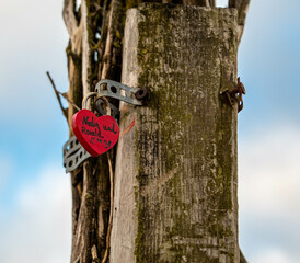 Fototapeta premium Rotes Liebesschloss an einem Holzpfahl 