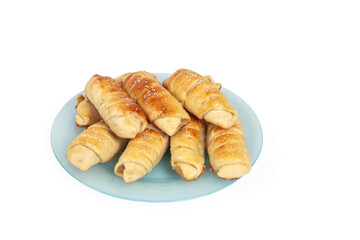 Croissants with sesame seeds on a blue plate are baked by yourself. Baking isolate on a white background