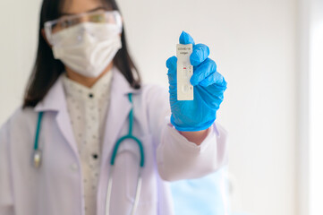 Fototapeta premium Young female doctor holding ATK kit in hospital, covid19 and pandemic concept