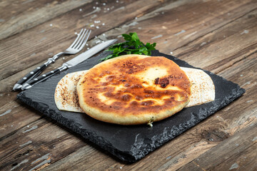 Traditional Ossetian feta cheese pie still life, with cheese, potatoes, herbs, cottage cheese, beef, mushrooms. National Caucasian dish, top view