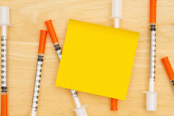 Disposable vaccine needle on desk with a sticky note