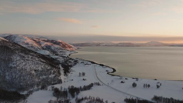 Beautiful aerial shot of Kvaloya island in Norway. Snowy mountain and ocean landscape