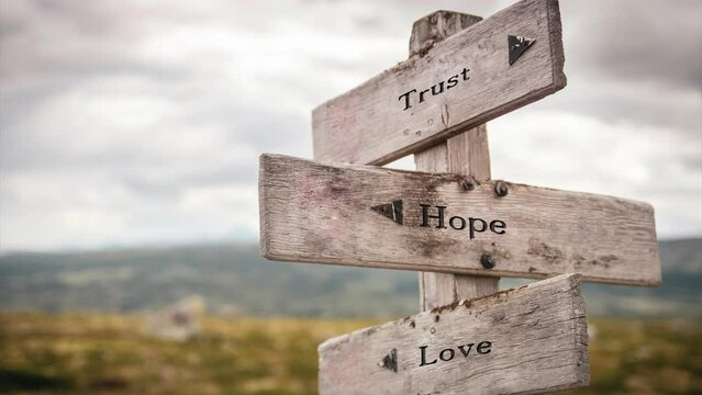 Trust hope and love text quote outdoors on wooden sign in nature. Slow zoom and pan video 4k footage.