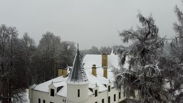 Rising aerial drone view of Alatskivi Castle in Estonia during winter