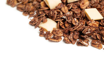 Granola with white chocolate pieces. Large amount of chocolate covered baked rolled oats clusters, randomly placed. Cereal background or healthy snack texture. Isolated on white. Selective focus.