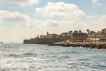 Fototapeta na wymiar View from the boat to the Mediterranean Sea, the fortress wall and buildings in the old city of Acre in northern Israel