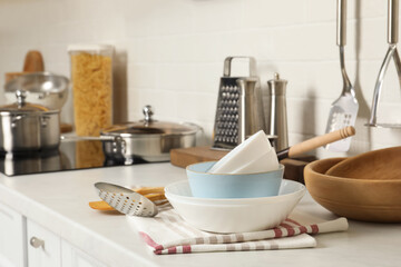 Stack of bowls and different cooking utensils on kitchen counter