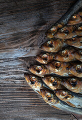 Cold smoked fish on an old wooden board with spices.