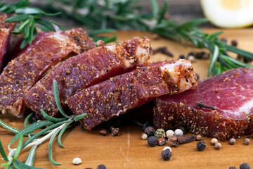 dried and spiced meat sliced on a wooden board