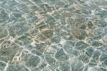 Close up, clear blue water, in the pool shines on a summer day.