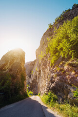 Narrow road pass between rocky cliffs vertical