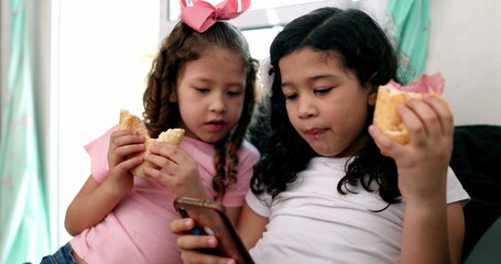 Kids eating sandwiches while looking at smartphone, children snacking while on social media
