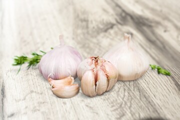 Falling peeled garlic cloves on wooden desk