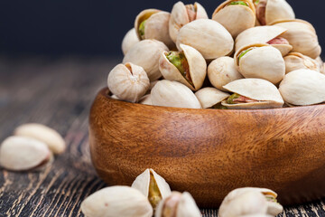 large number of pistachios on a wooden table
