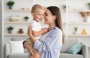 Mother And Child. Happy Young Woman Embracing Cute Infant Son At Home