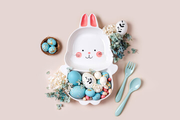 Easter table setting decoration with cute plate in the shape of a bunny with  Easter eggs and candy. Happy Easter concept. Idea for Easter dinner