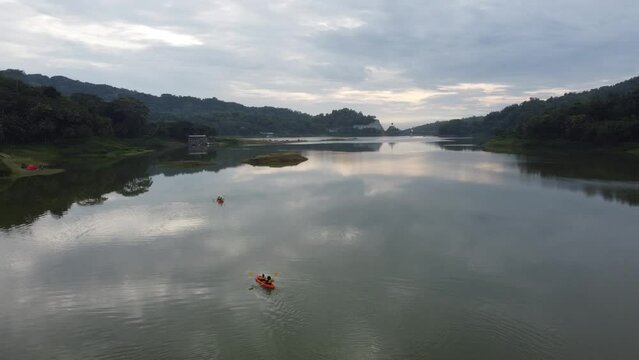 Asian People canoeing on a reservoir in the morning with a beautiful view