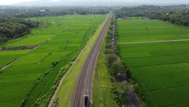Drone view of a train crossing between rice fields and beautiful scenery