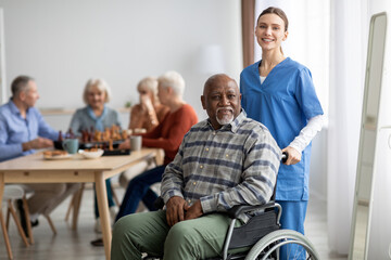 Happy older patient on wheelchair with female nurse
