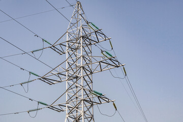 Power lines and towers - a modern high voltage power system. Against the background of the blue sky.